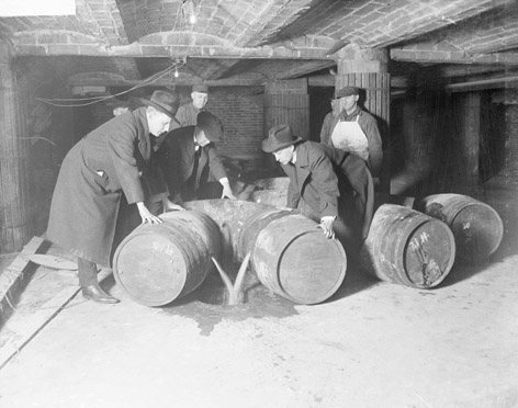 Prohibition agents destroy barrels of alcohol.